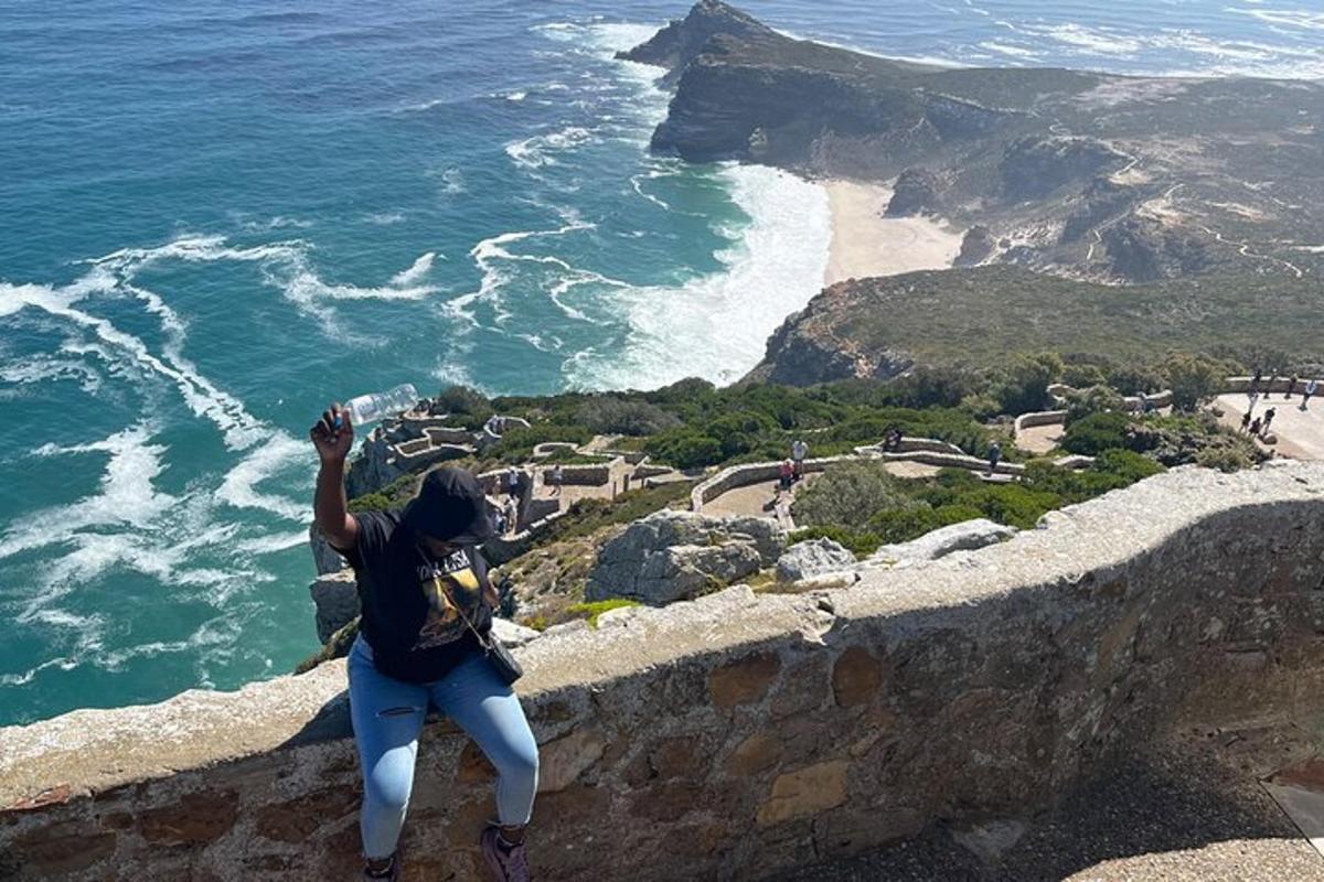 una persona parada en el borde de un acantilado con vista al océano