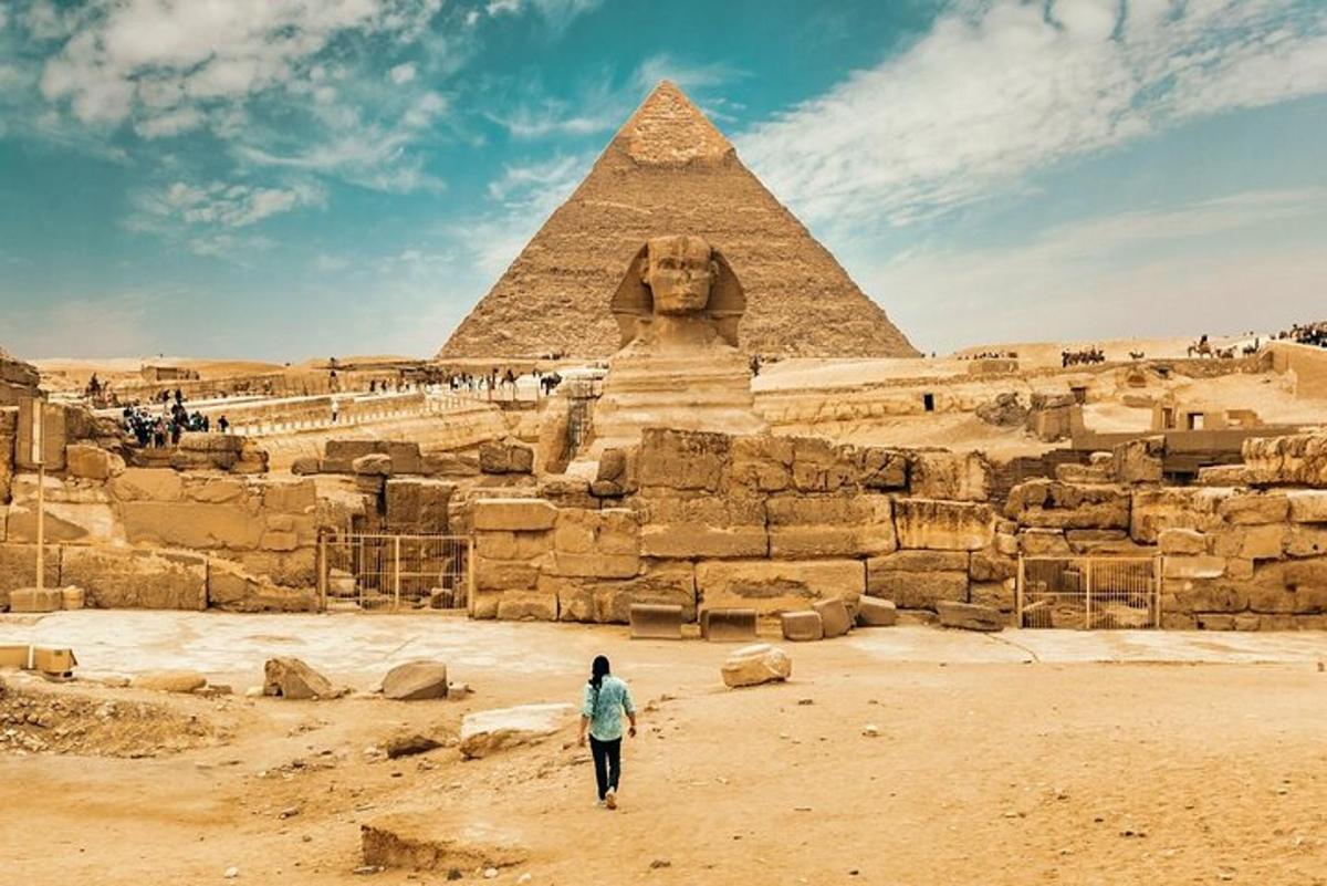امرأة تمشي أمام الأهرامات