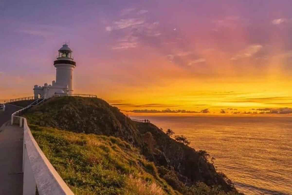 a lighthouse on a hill next to the ocean