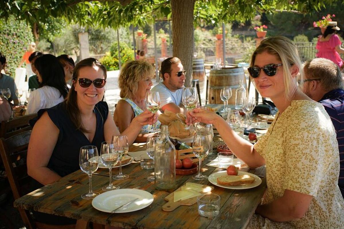 un gruppo di persone sedute a un tavolo con bicchieri di vino