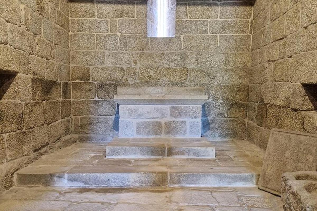 uma sala de pedra com uma parede de tijolos e escadas