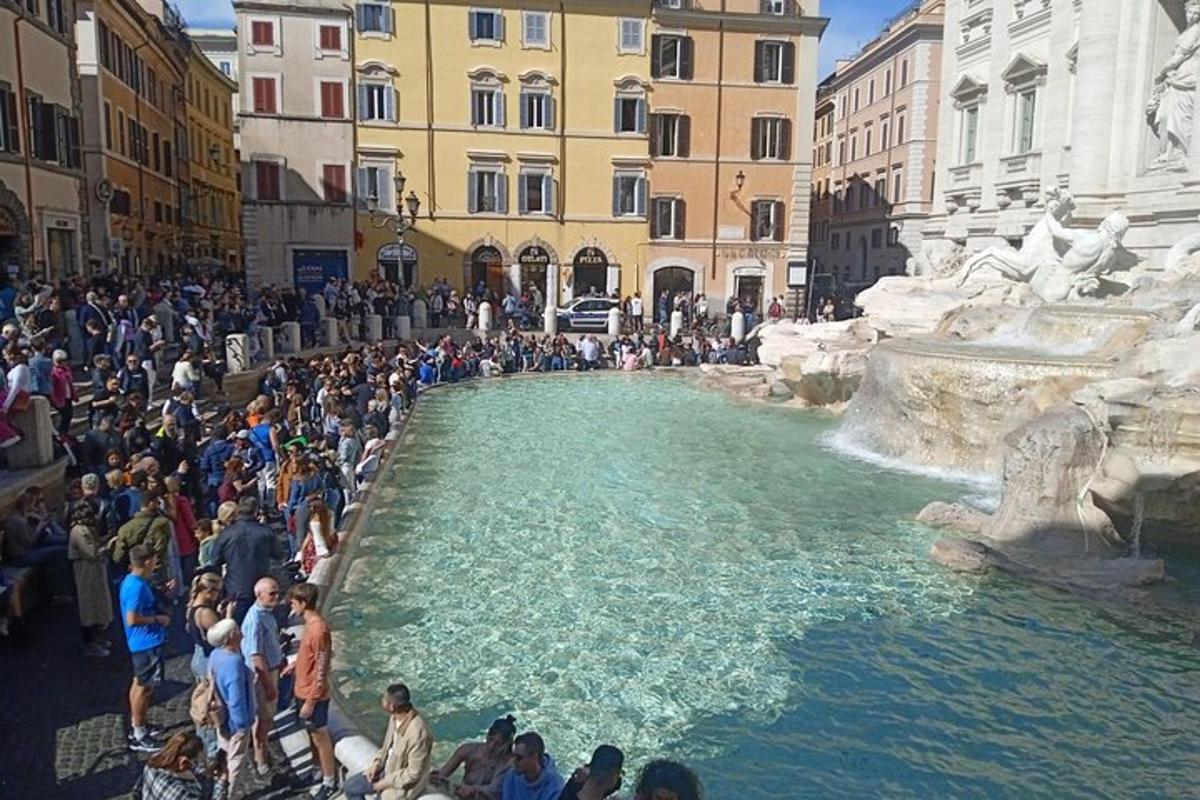 a crowd of people standing around a fountain in a city