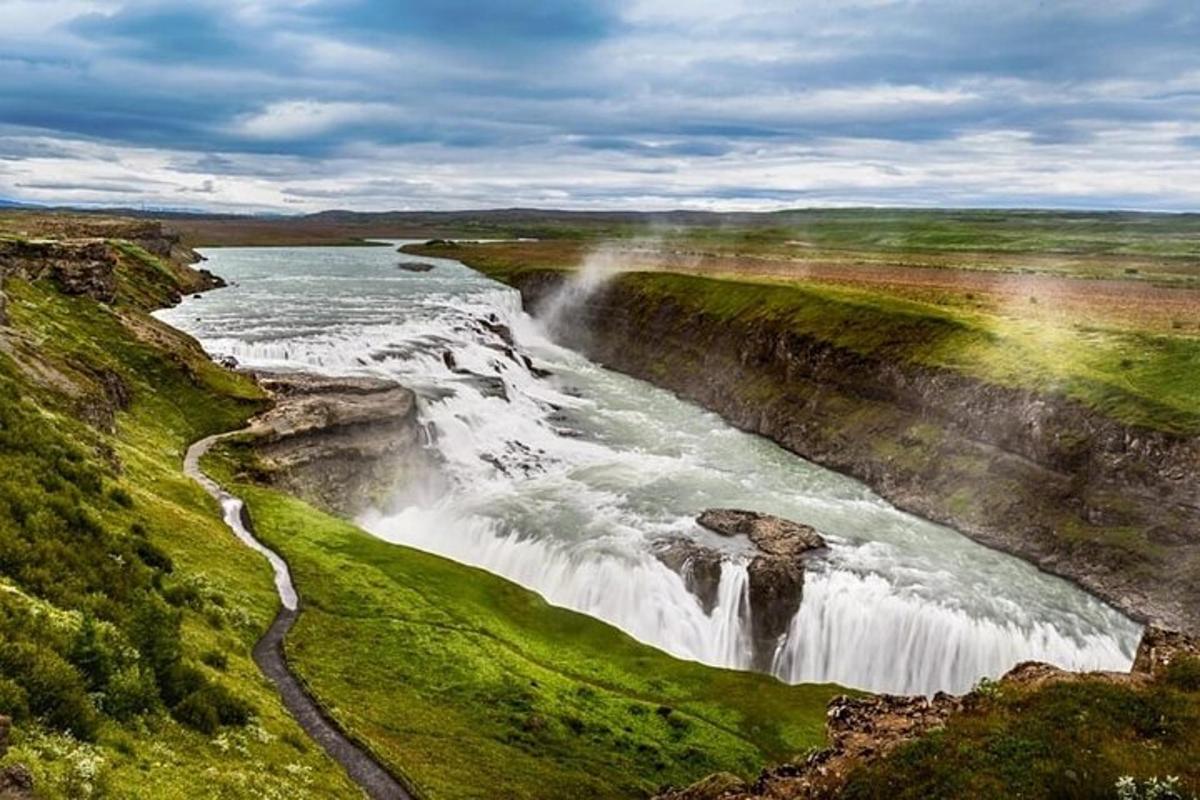 foss með regnboga við bakka árinnar