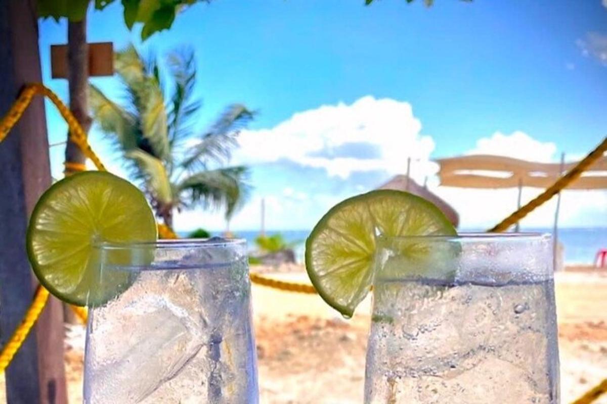 two glasses of water with a lime slice on the beach