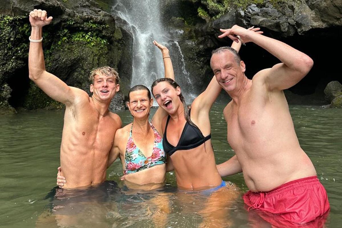 Un grupo de personas en el agua cerca de una cascada.