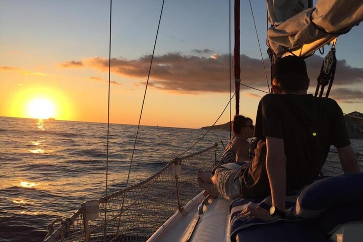 a group of people sitting on a boat watching the sunset