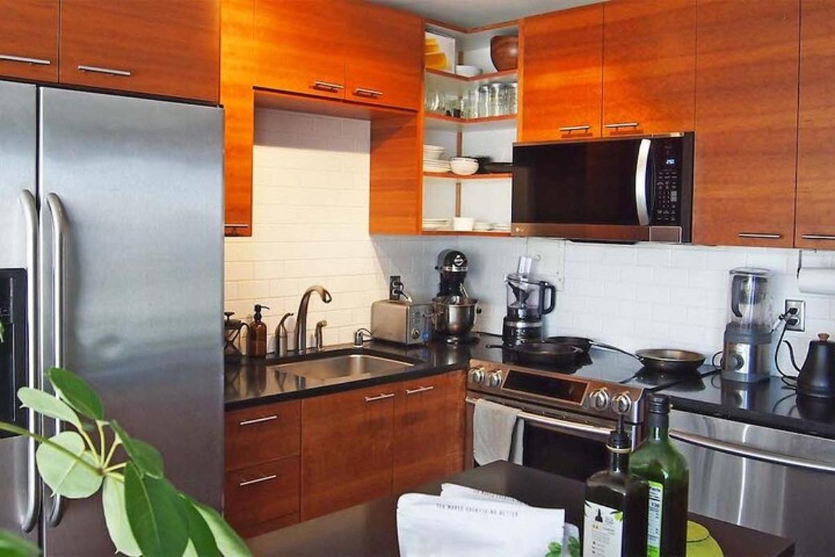 dapur dengan peralatan keluli tahan karat dan kabinet kayu