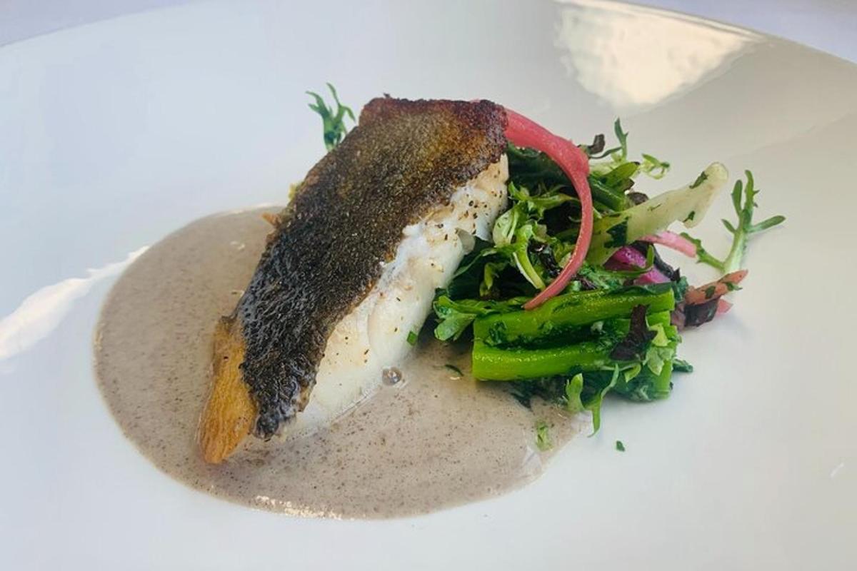 sekeping ikan dengan salad di atas pinggan putih