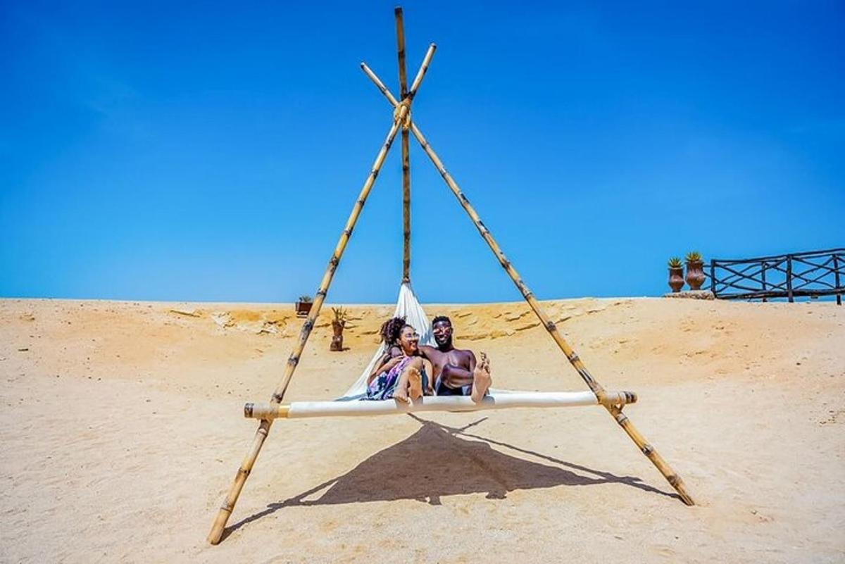 dva človeka sedita na gugalnici na plaži