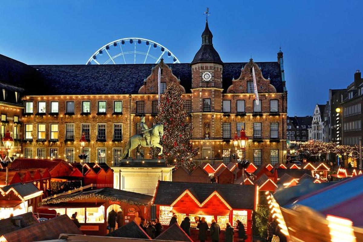 a christmas market in front of a building with a christmas tree