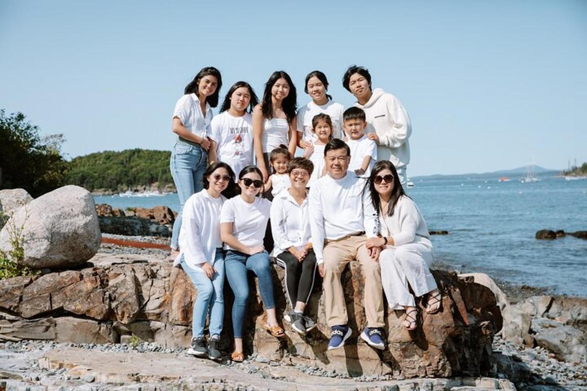 um grupo de pessoas sentadas em pedras na praia