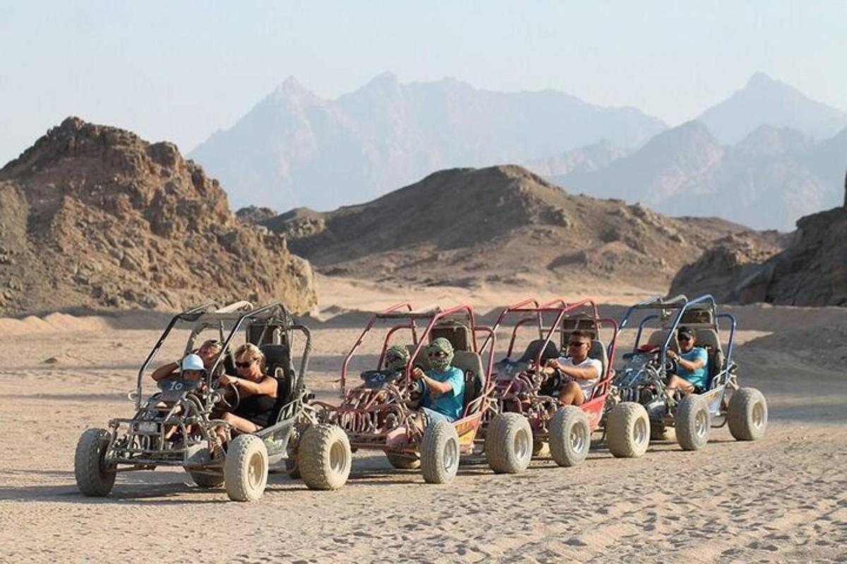 Un grupo de personas viajando en vehículos de cuatro ruedas en el desierto.