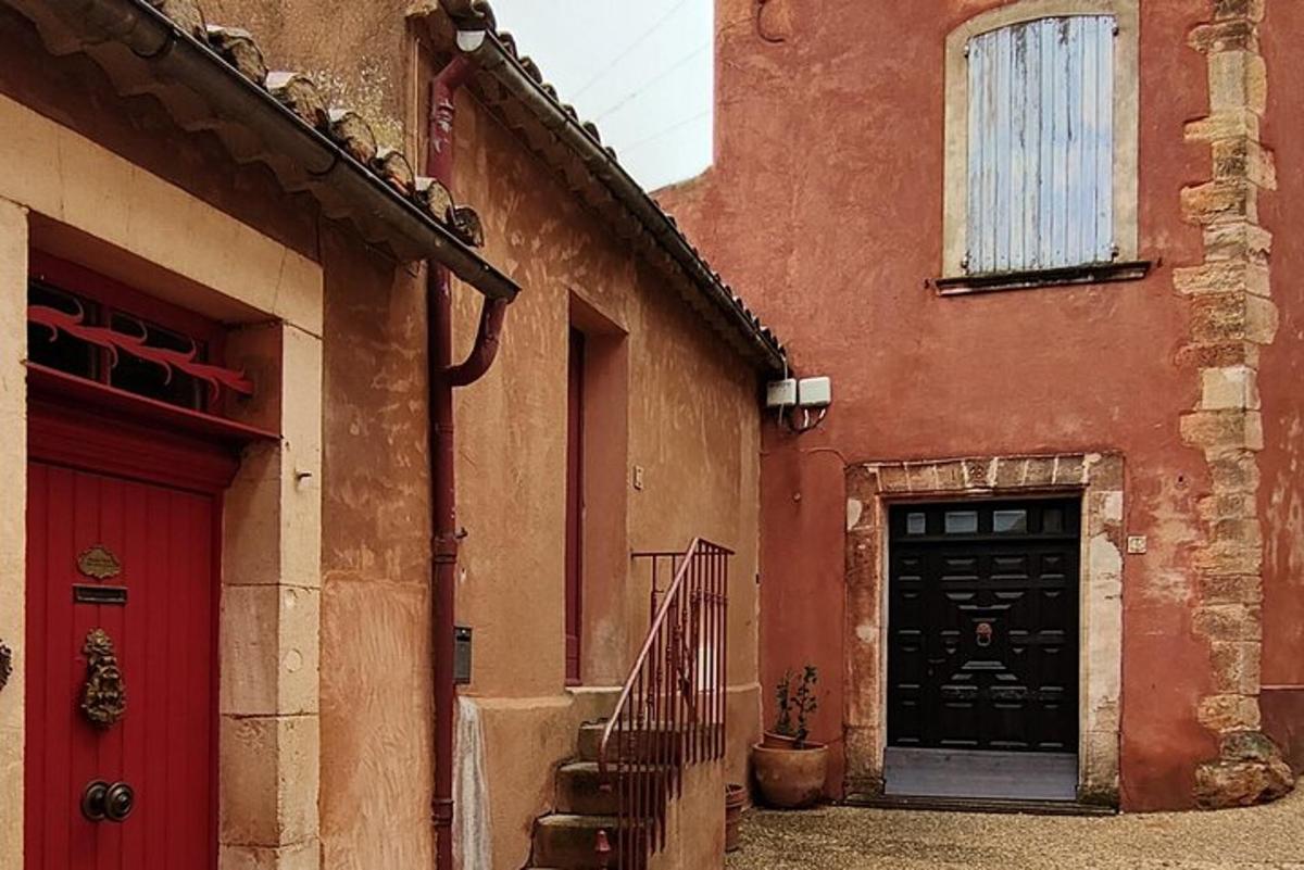 Un edificio rojo con una puerta negra y una escalera.