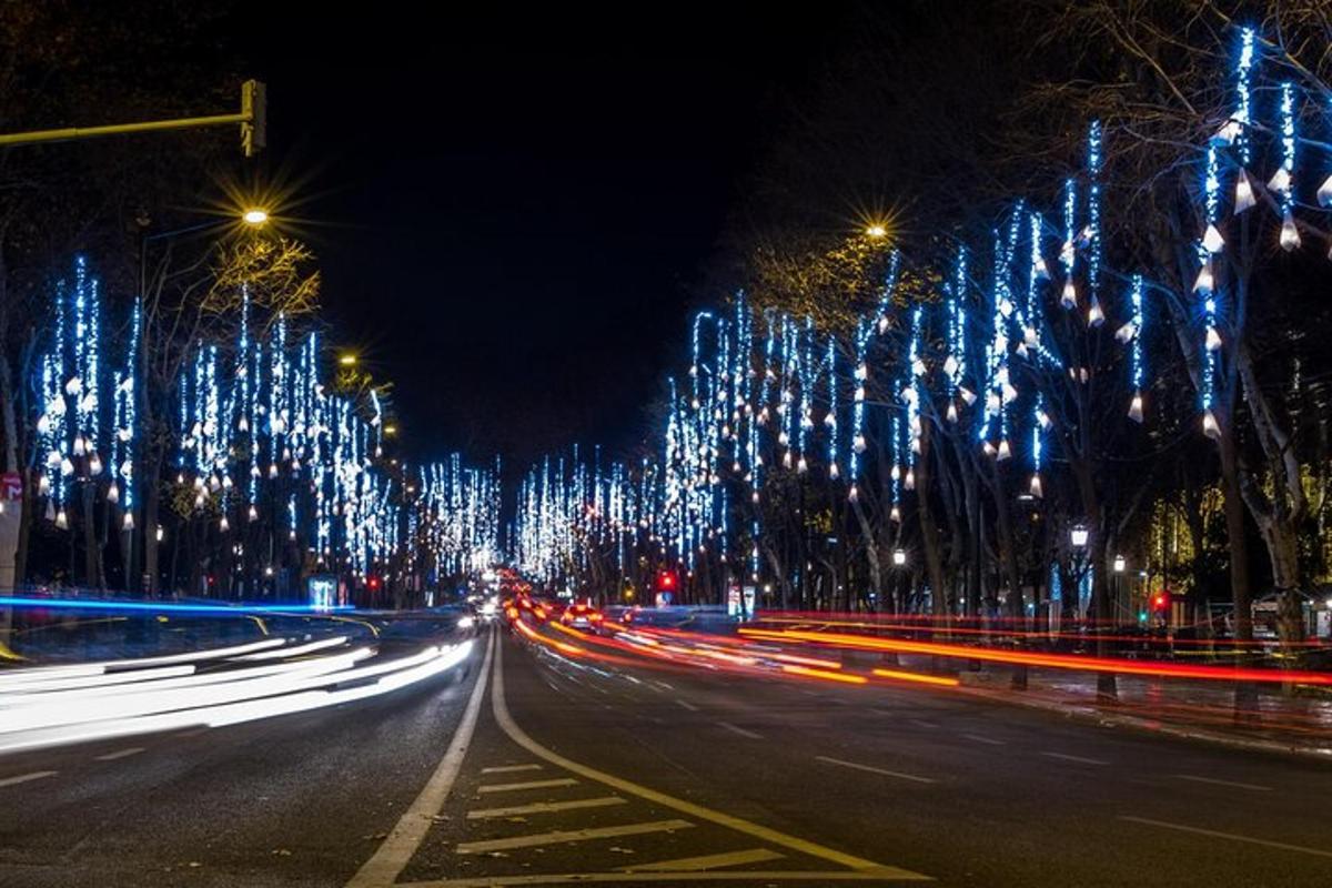 a city street at night with christmas lights on trees