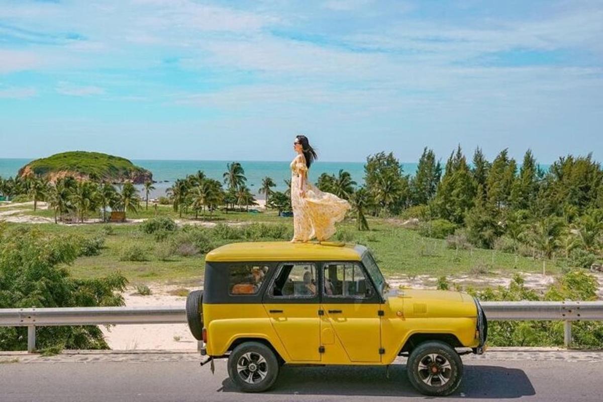 una donna è in piedi sopra un'auto gialla