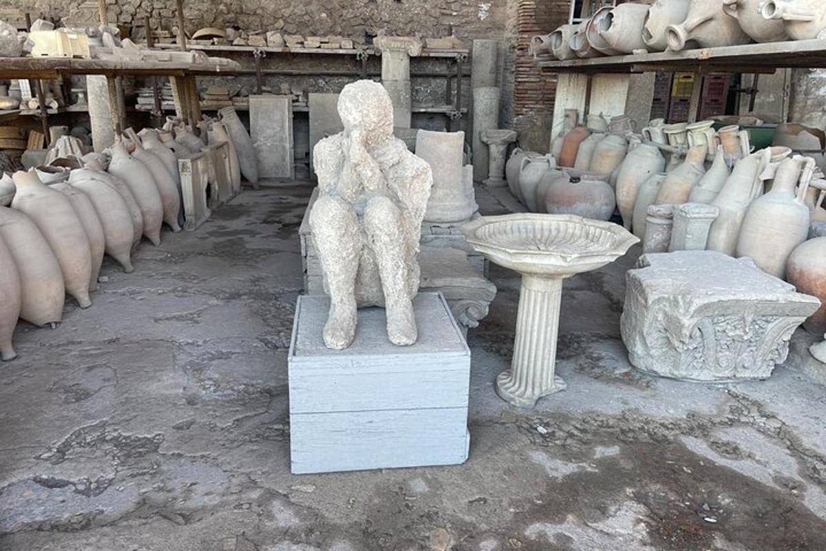 una estàtua d'un ós assegut en un pedestal en una habitació amb gerros