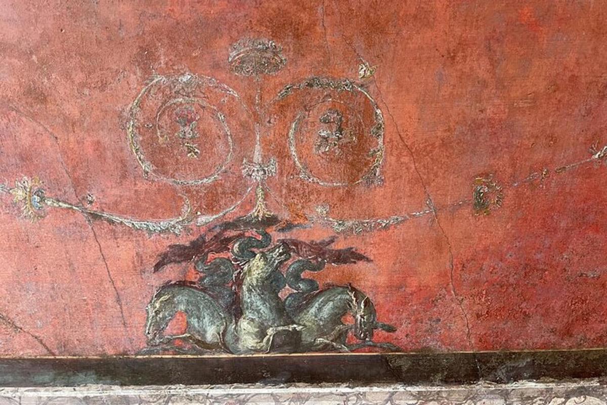 una pintura d'un cavall sobre una paret vermella