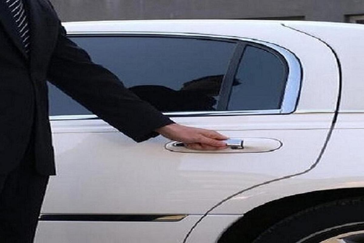 um homem abrindo a porta de um carro branco com a mão