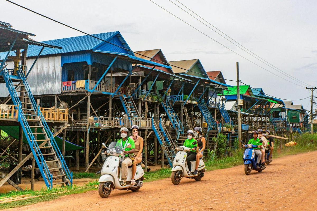 một nhóm người đang đi xe tay ga trên một con đường đất