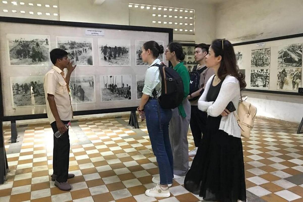 un grup de persones dretes en una sala mirant una exposició