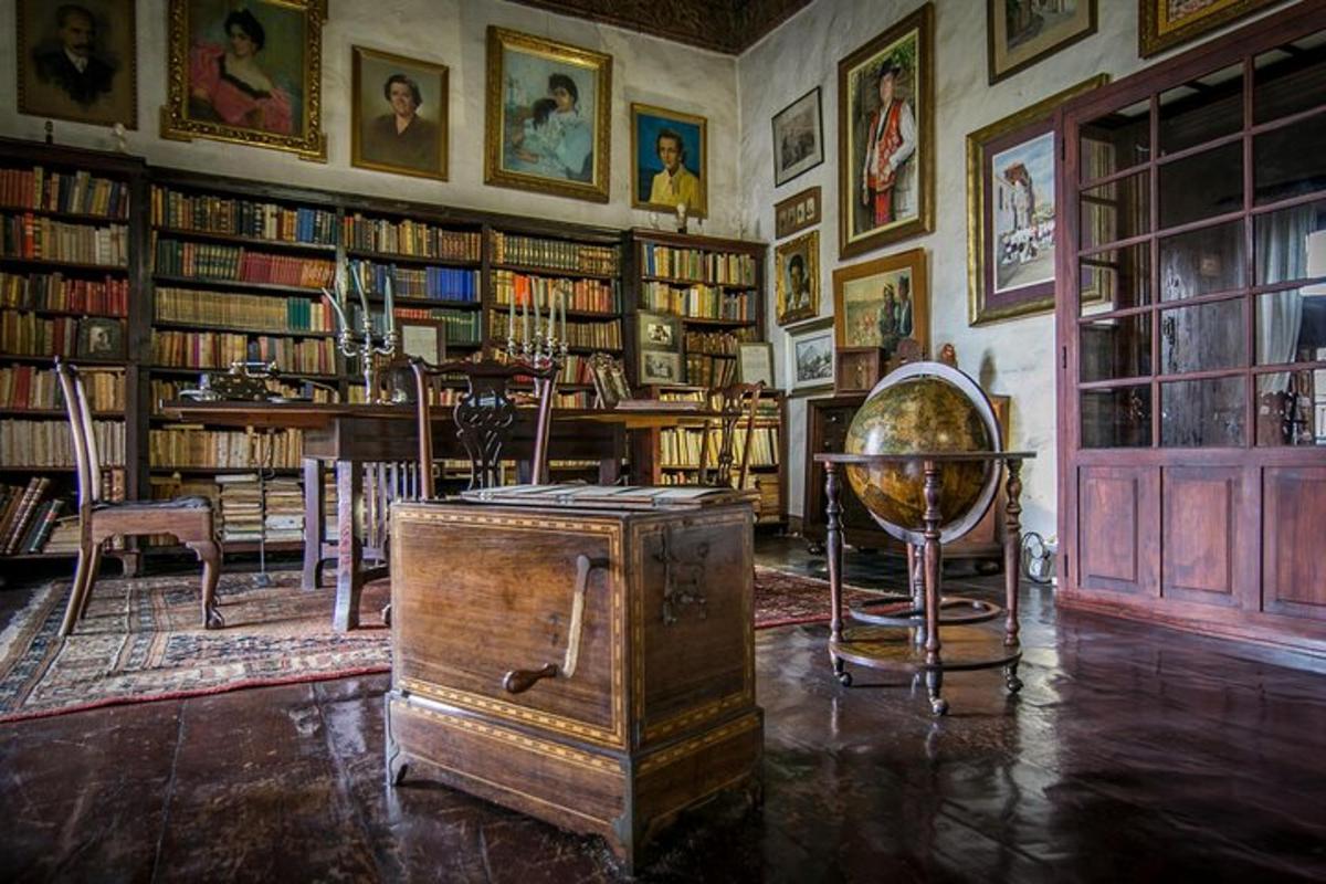 a room with a library with bookshelves and a room with a globe