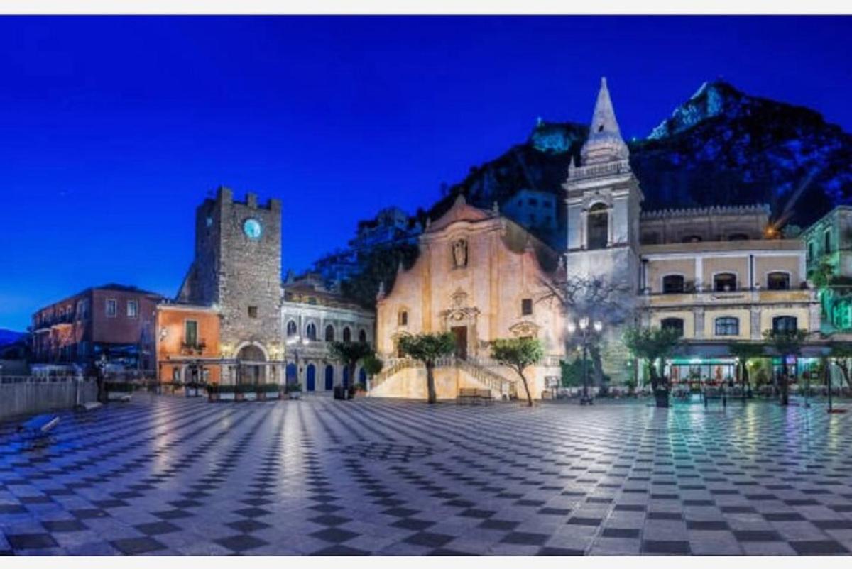 un grande edificio con una torre dell'orologio e una montagna