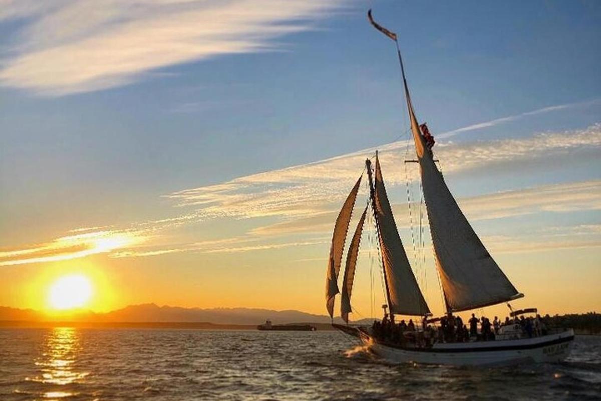 un gruppo di persone su una barca a vela in acqua al tramonto