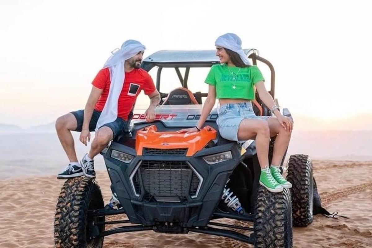 due persone sedute su un quad sulla spiaggia