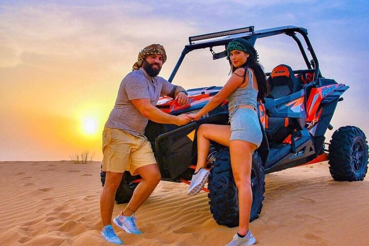 un uomo e una donna in piedi su una jeep nel deserto