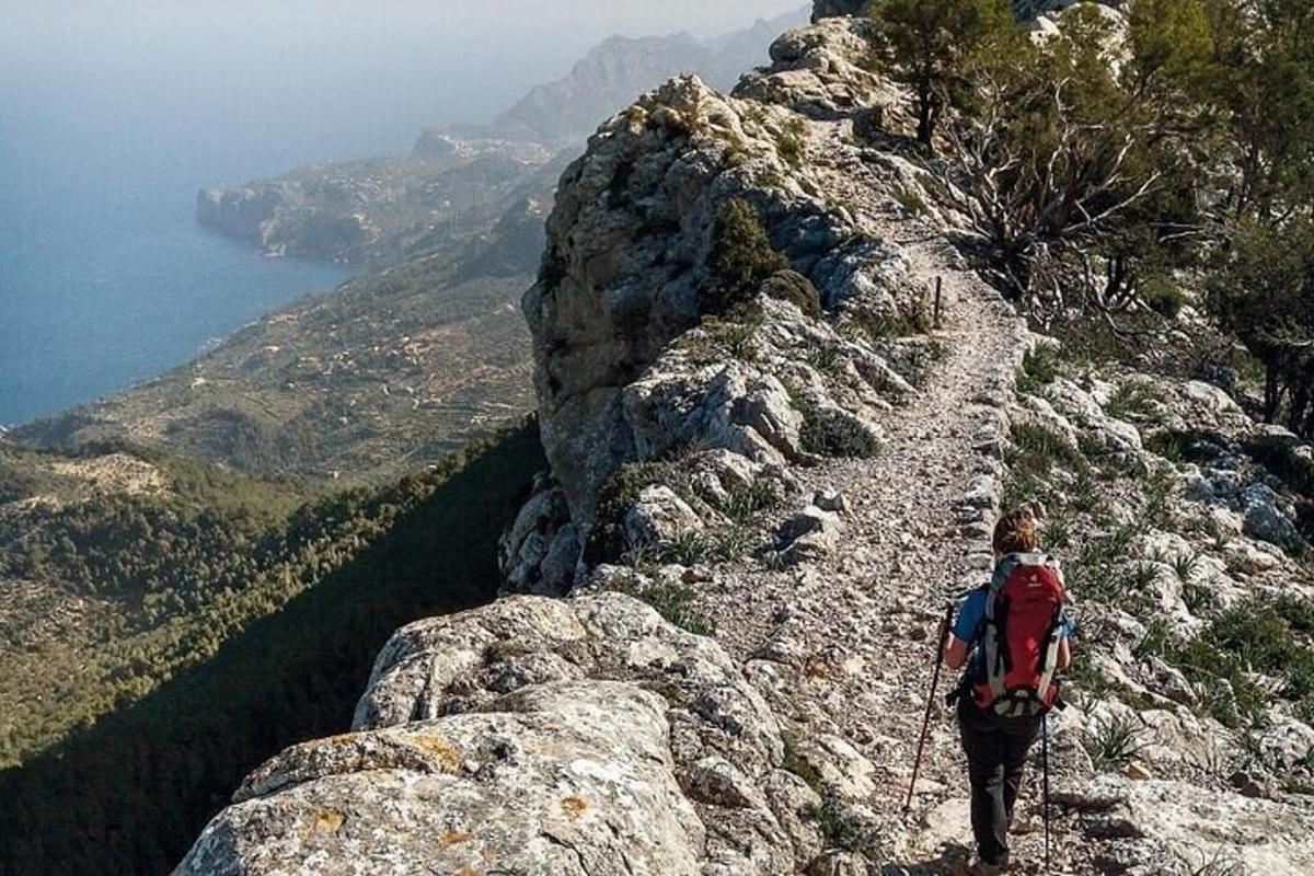 una persona pujant una muntanya rocosa amb una motxilla