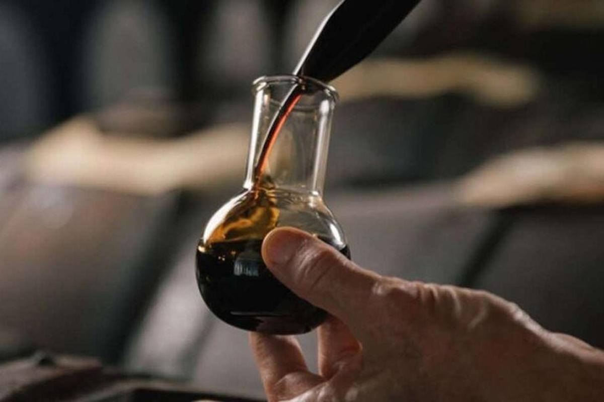 Una persona sostiene una copa de vino tinto.