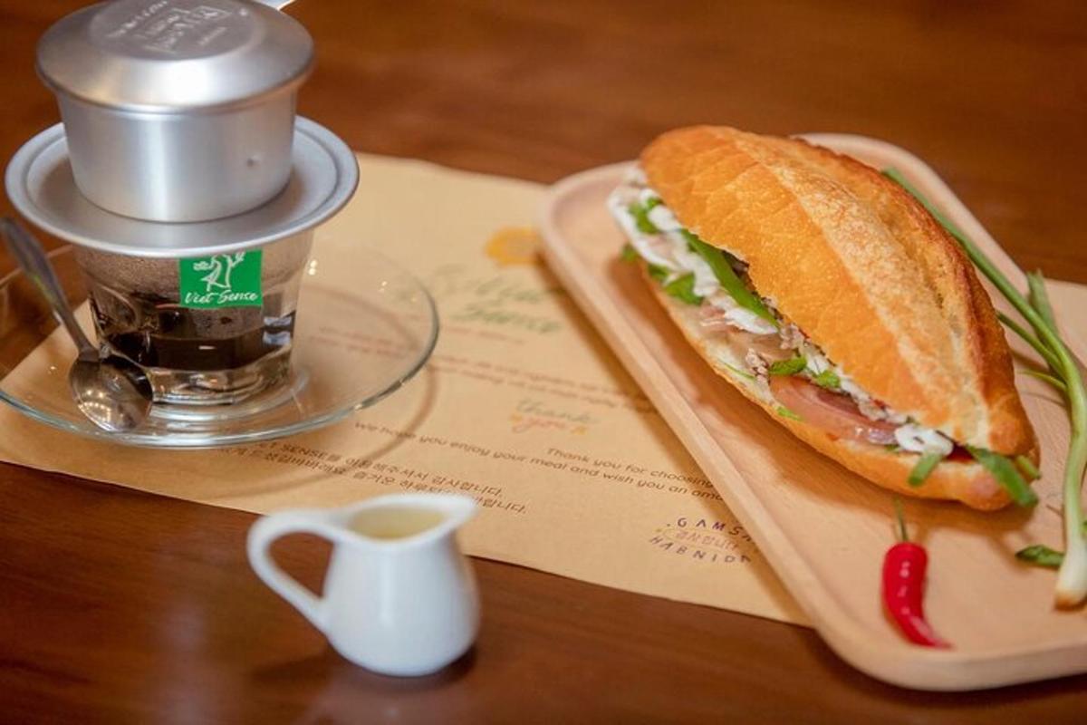 Un sándwich sobre una mesa junto a una taza de café.