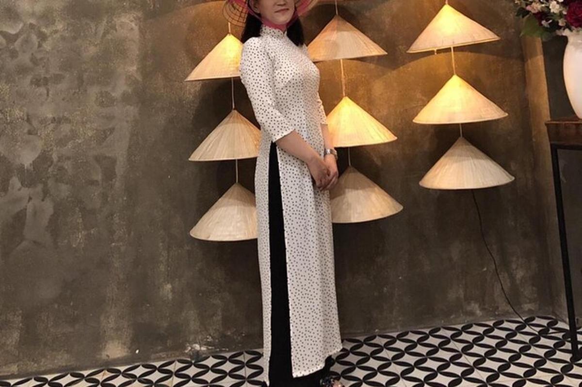 Una mujer con un vestido parada frente a una pared.