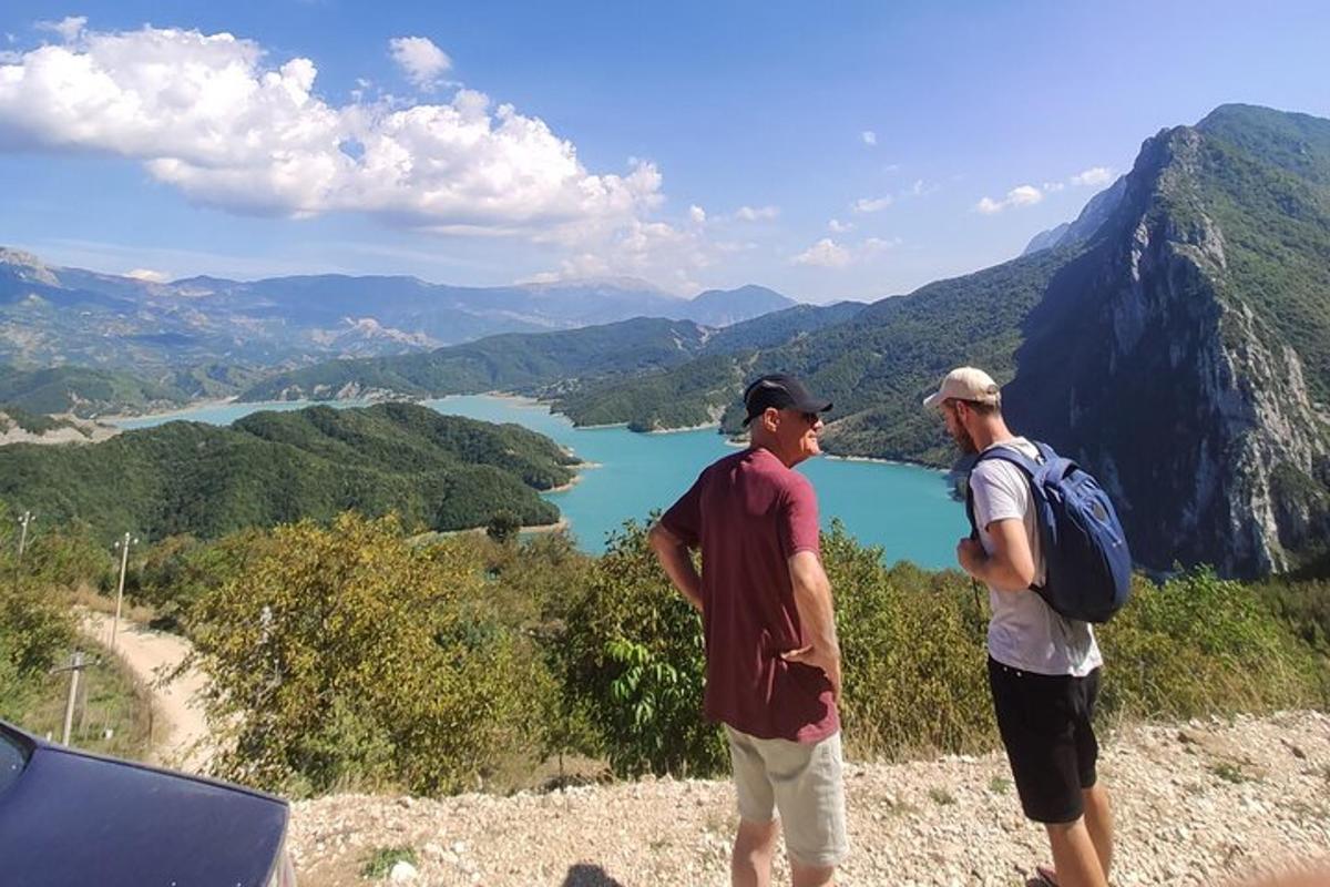dva muži stojící na vrcholu hory s výhledem na jezero