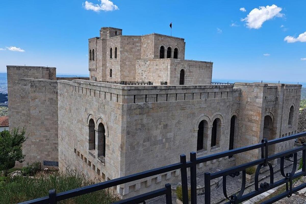 Un gran edificio de ladrillo con una valla delante.
