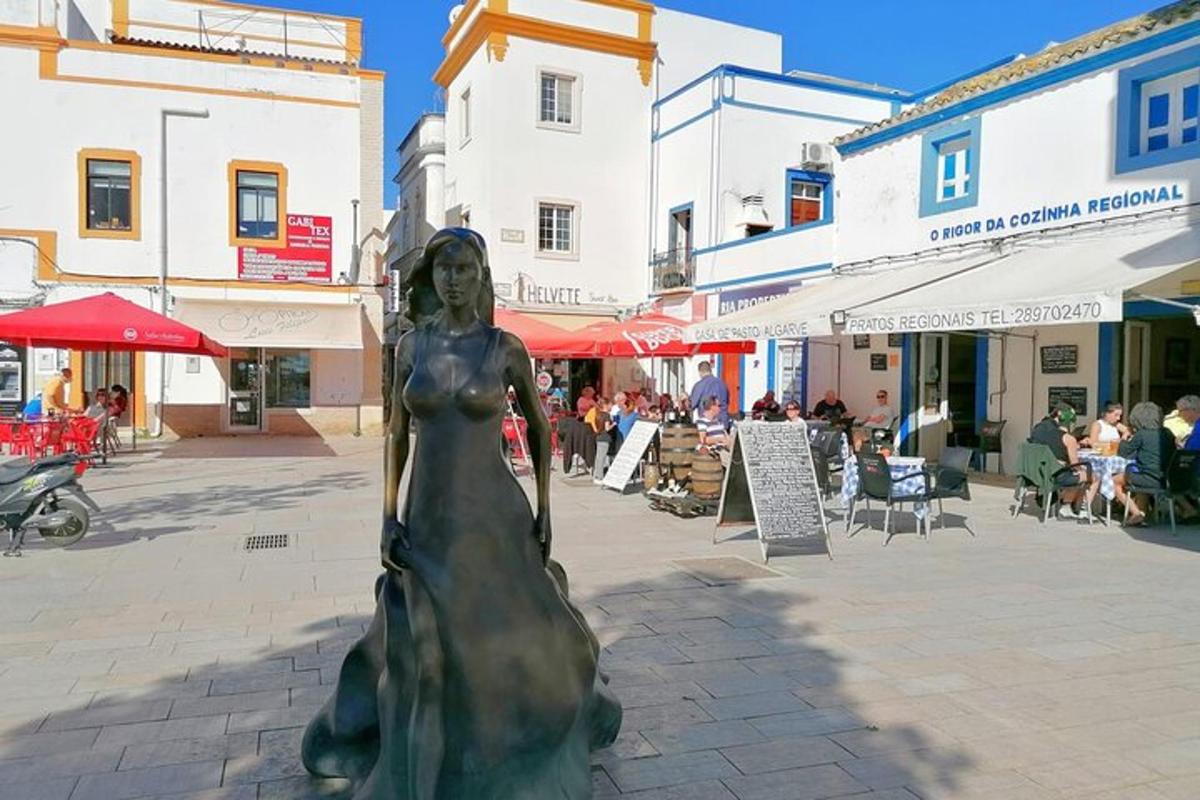 a statue of a woman in a dress on a street