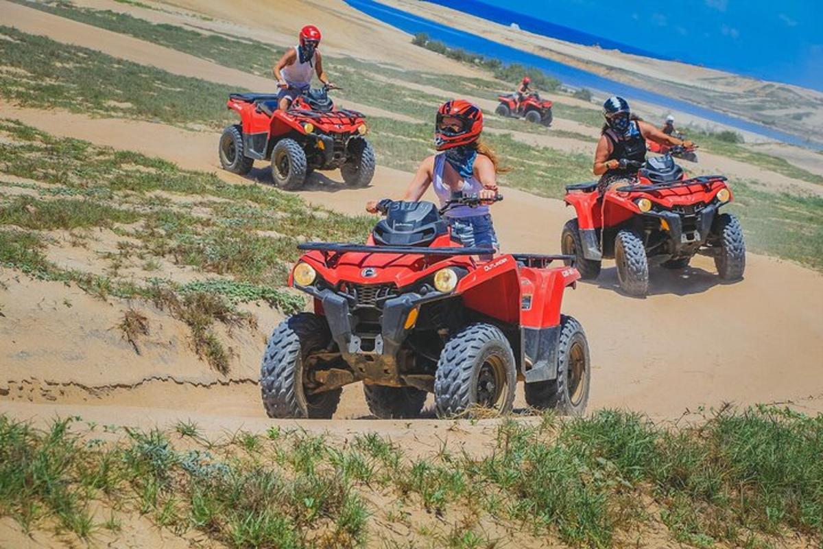 isang grupo ng mga tao na nakasakay sa mga atv sa isang beach