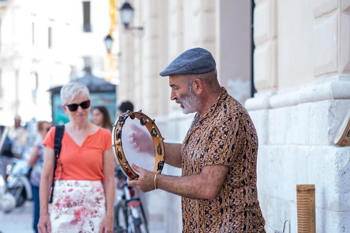 a man is holding a large instrument in a street