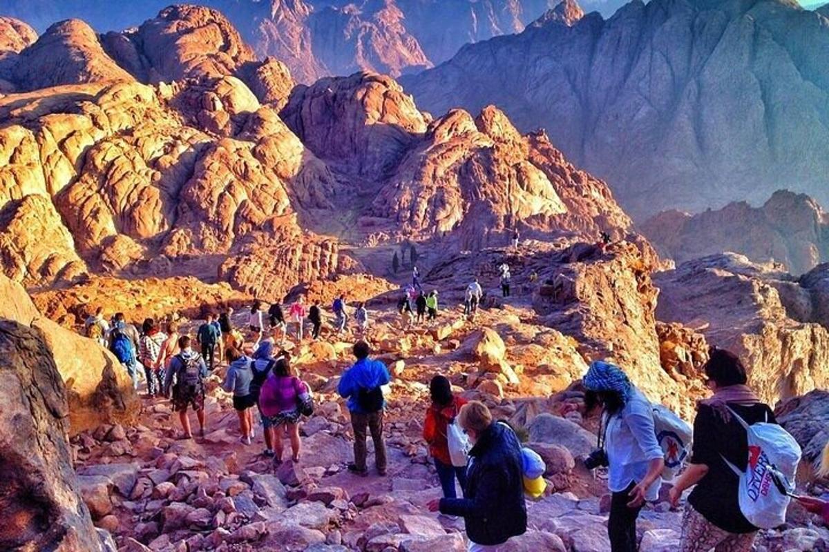 sekumpulan orang berjalan di atas gunung berbatu