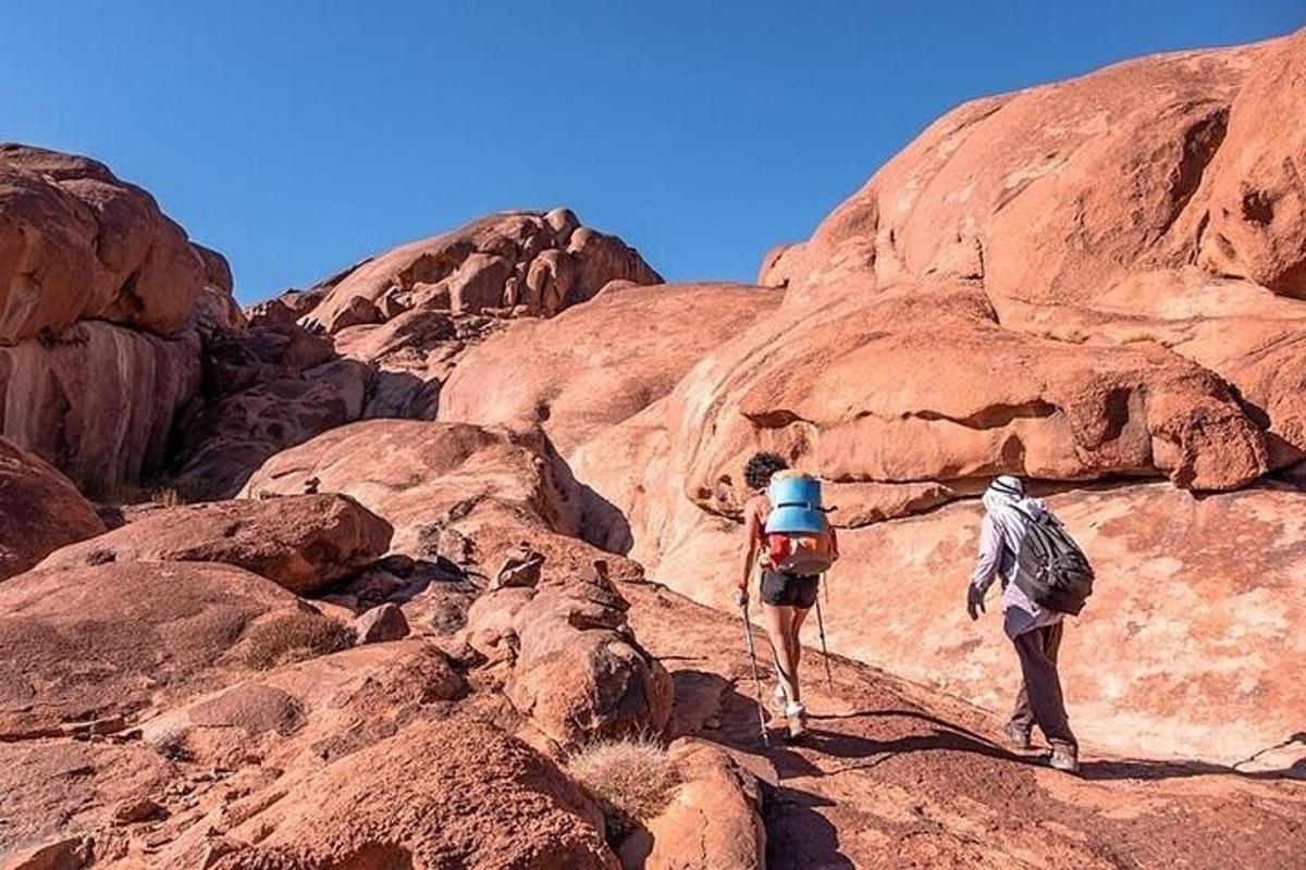 dua orang berjalan di atas gunung berbatu