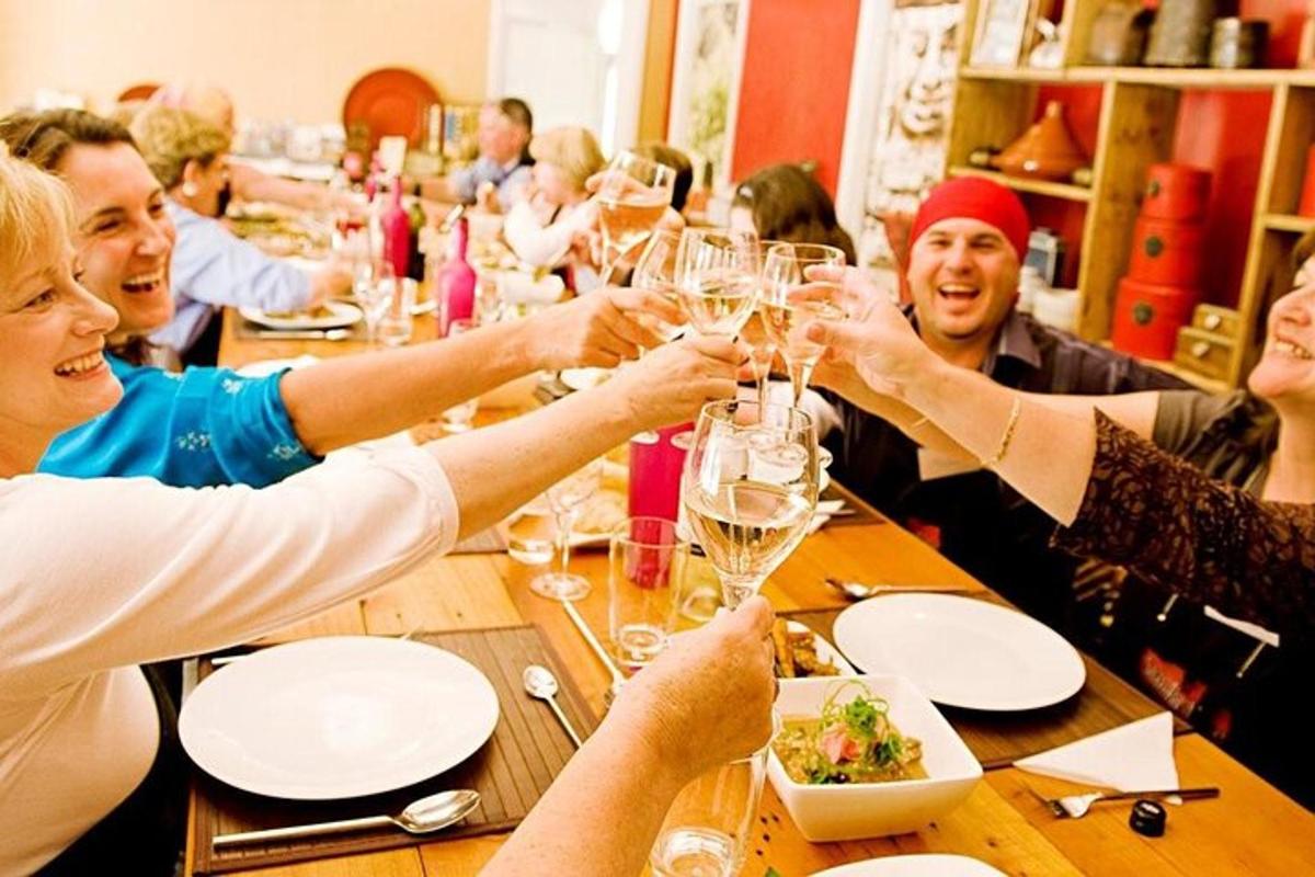 Un grupo de personas sentadas alrededor de una mesa bebiendo vino.