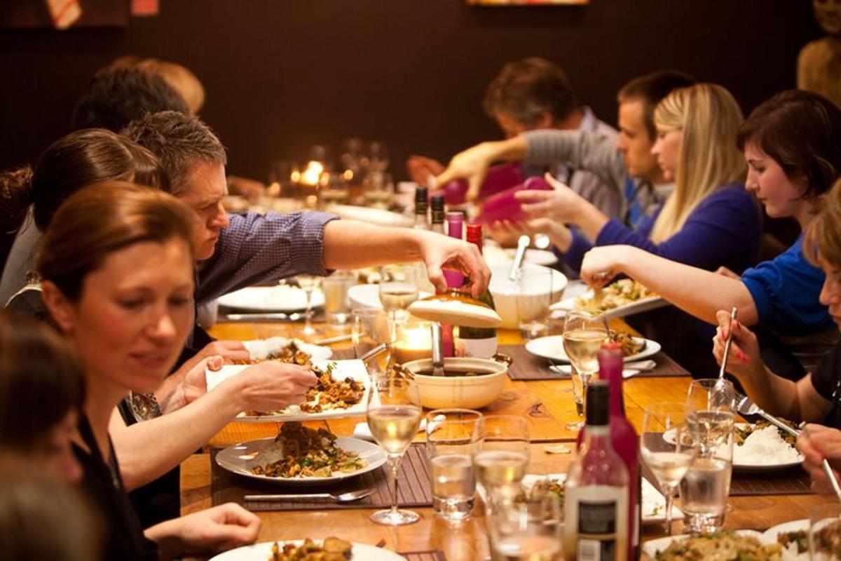Un grupo de personas sentadas en una mesa comiendo comida