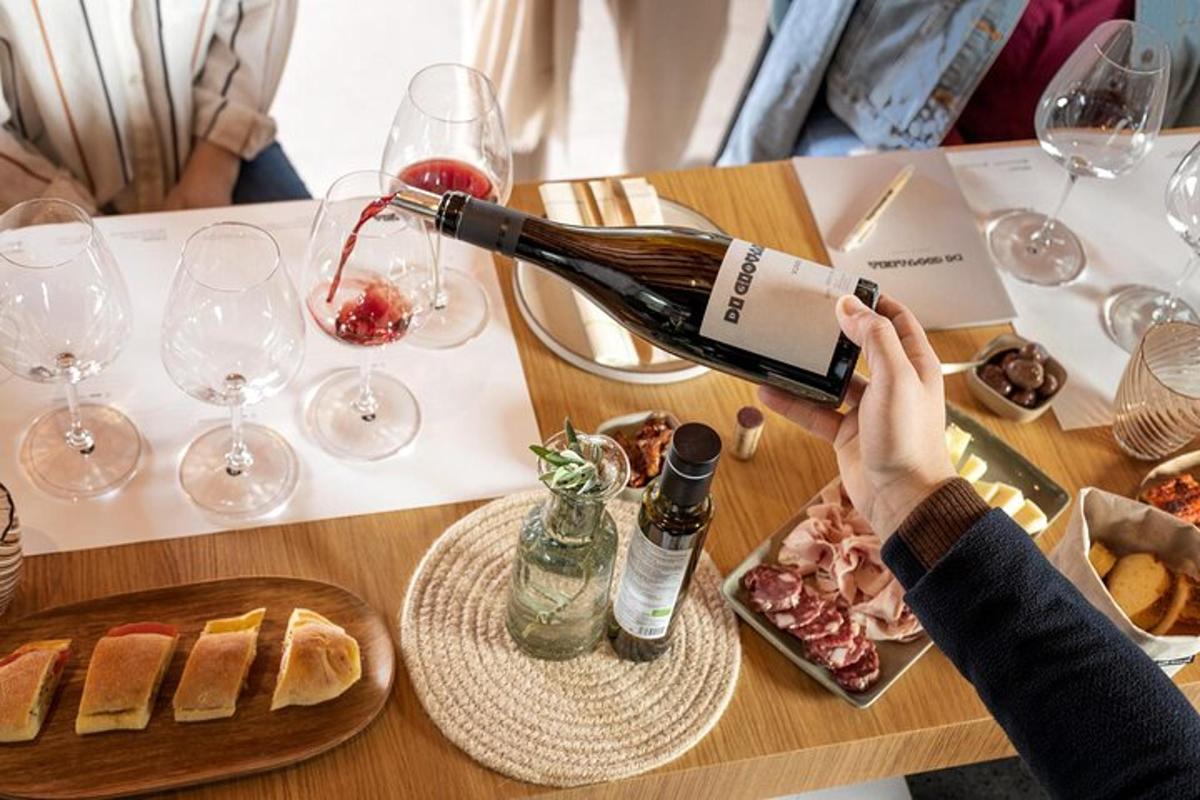 uma pessoa está despejando uma garrafa de vinho sobre uma mesa