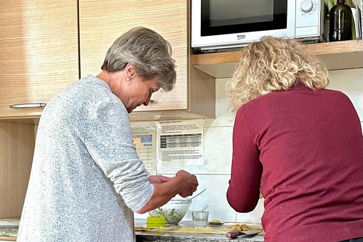 starší žena stojící v kuchyni a připravující jídlo