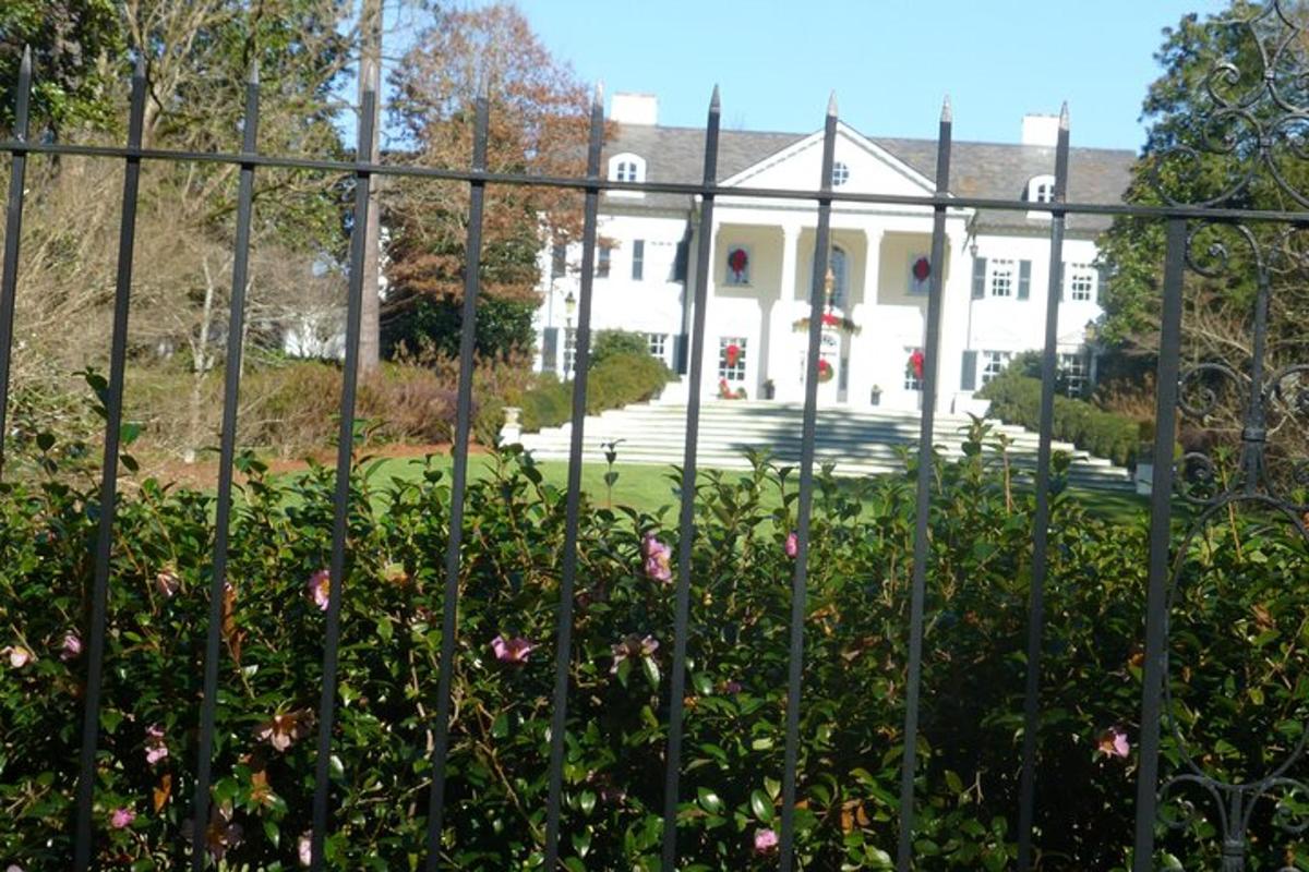 a fence with pink flowers in front of a house