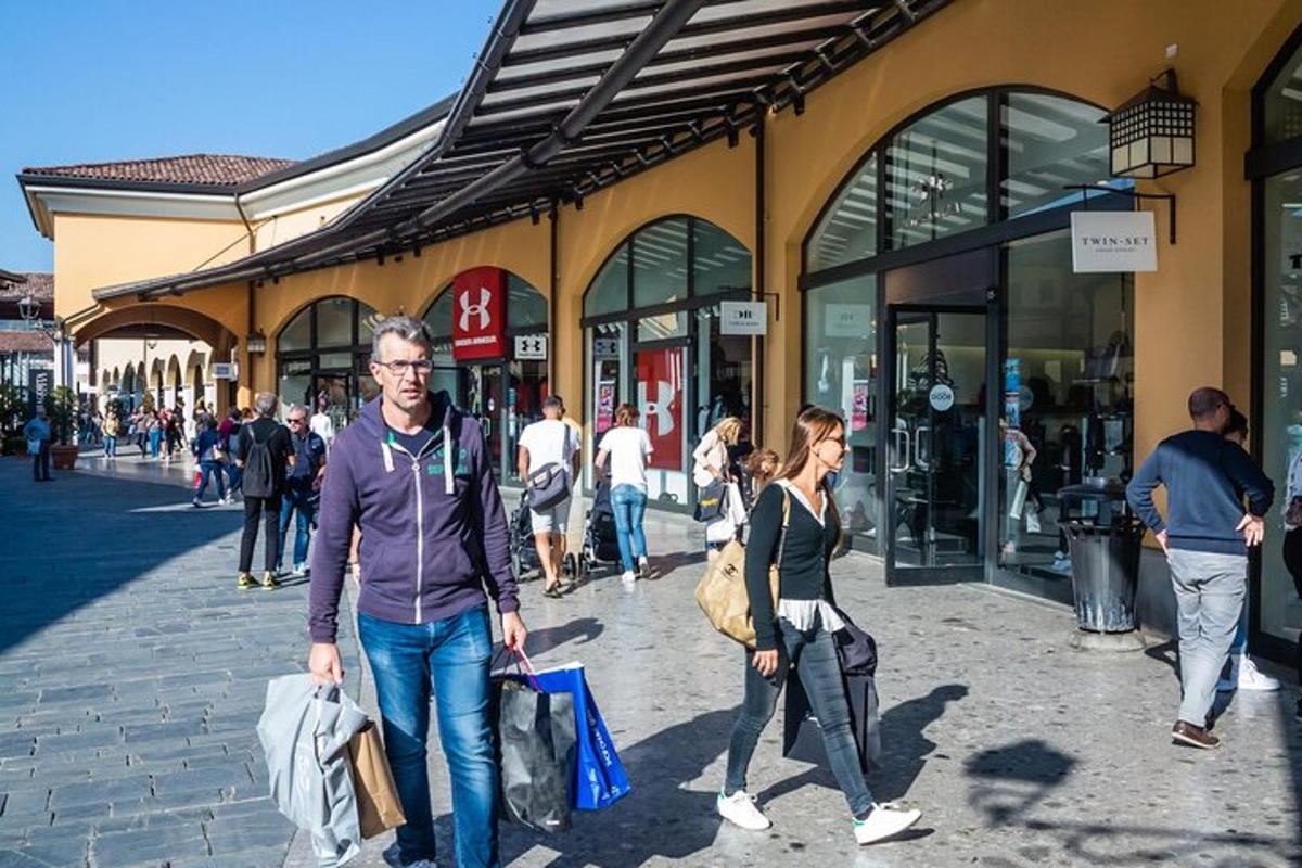 un bărbat și o femeie mergând prin fața unui magazin