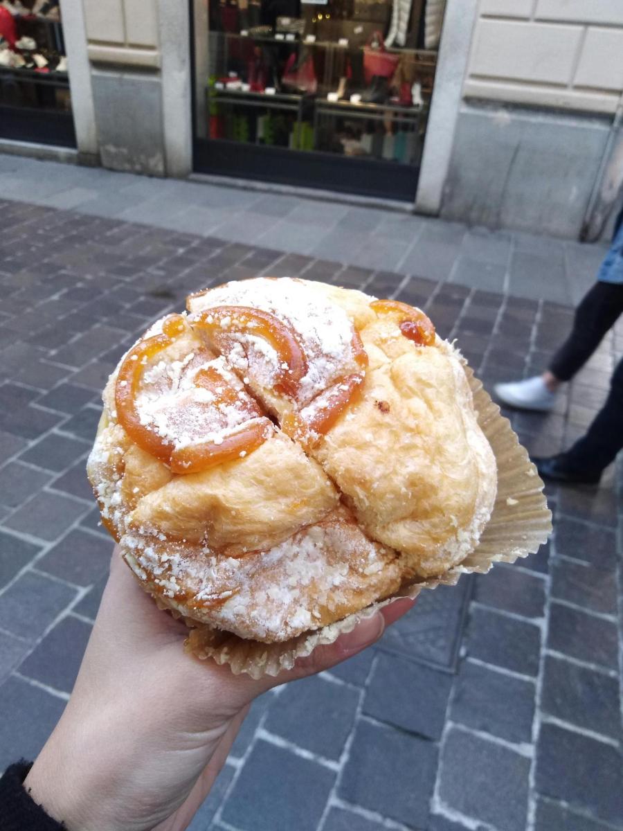 osoba držící pečivo s moučkovým cukrem