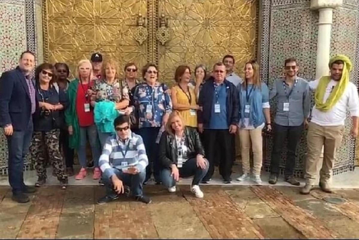 bir binanın önünde fotoğraf çektiren bir grup insan