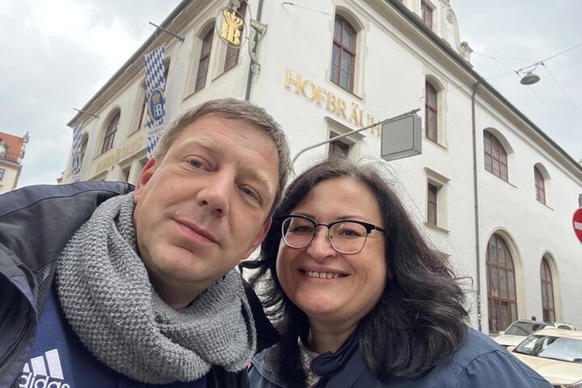 karlmaður og kona standa fyrir framan byggingu