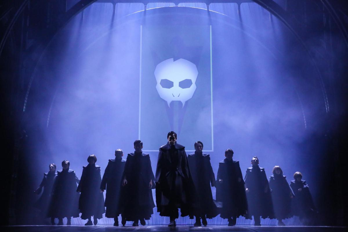 grupa ludzi stojących na scenie w maskach